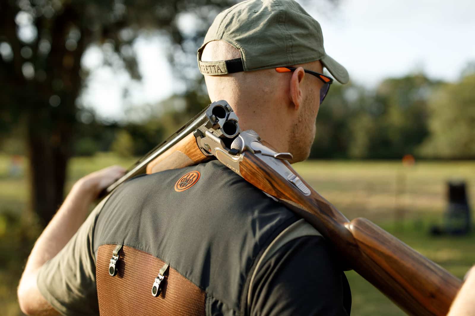 man holding firearm over back